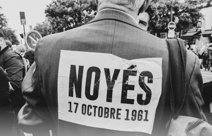 Photo du dos d'un manifestant avec un message accroché sur son dos "Noyés, 17 octobre 1961"