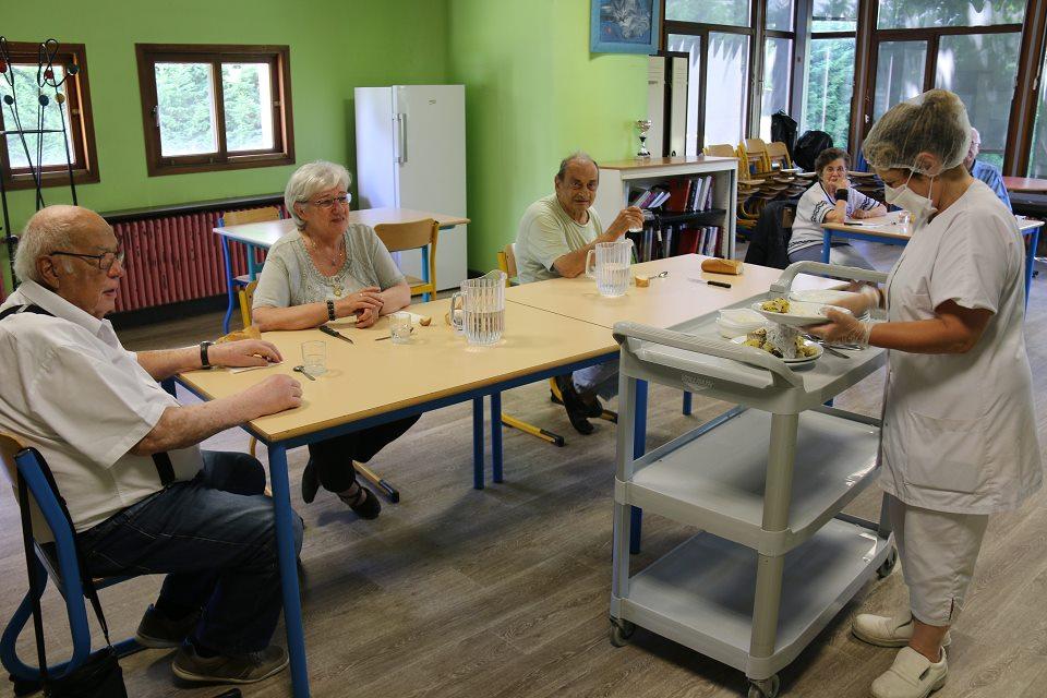 Le personnel du foyer-restaurant des Ecureuils débarrasse les tables.