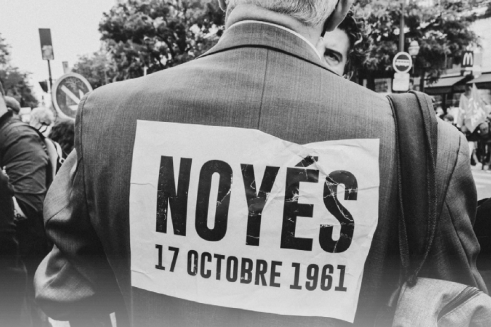 Photo du dos d'un manifestant avec un message accroché sur son dos "Noyés, 17 octobre 1961"